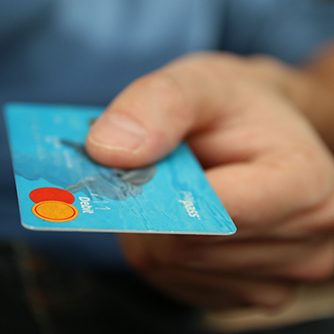 Close up of man holding a blue debit card