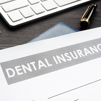 Dental insurance form and money on desk.