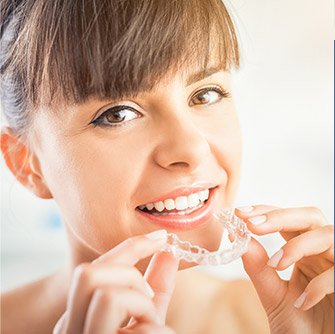 Woman holding Invisalign tray