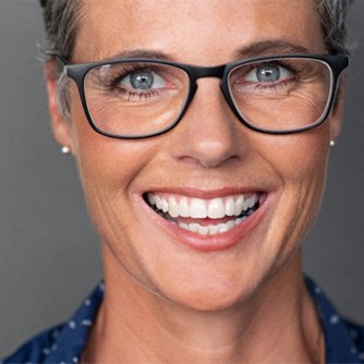 closeup of woman smiling with glasses on 
