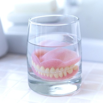 Dentures in Farmington soaking in solution in a white bathroom