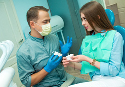Farmington patient talking to dentist before dental implants