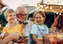Farmington patient smiling with family after dental implant restoration 