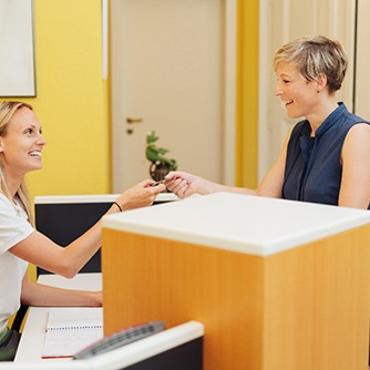 A woman paying the cost of Invisalign