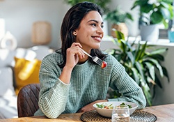Woman smiling while eating lunch at home