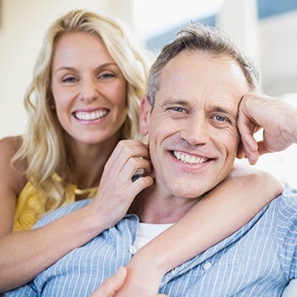 Smiling man and woman on couch