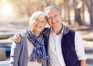 Older man and woman smiling outdoors