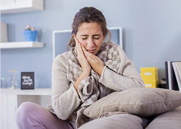 Woman holding cheek in pain