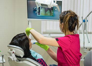 Dentist and patient looking at intraoral photos on computer screen