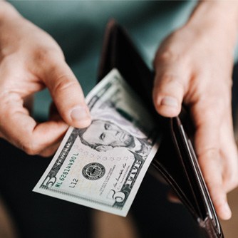 Man looking at cash in wallet