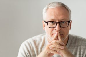 A man folding his hands in thought.