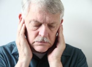 A man touching both sides of his jaw