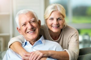 Smiling older couple with dental implants in Farmington