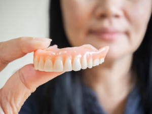 a person holding their dentures