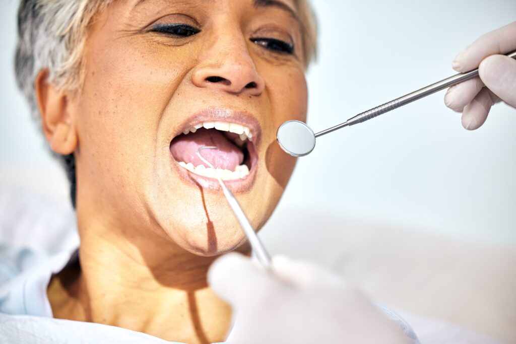 Woman with gray hair undergoing dental exam
